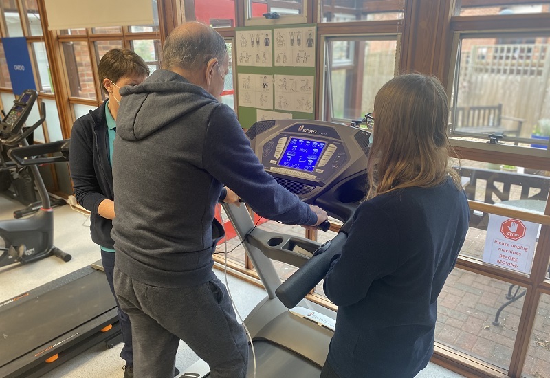 man-using-a-treadmill-observed-by-rehabilitation-staff