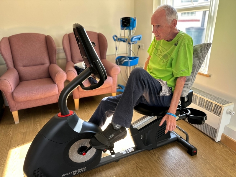 patient-kent-sitting-on-an-exercise-bike-in-a-rehab-and-wellbeing-session