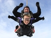 skydiver-and-instructor-smile-at-camera-with-thumbs-up-and-waving