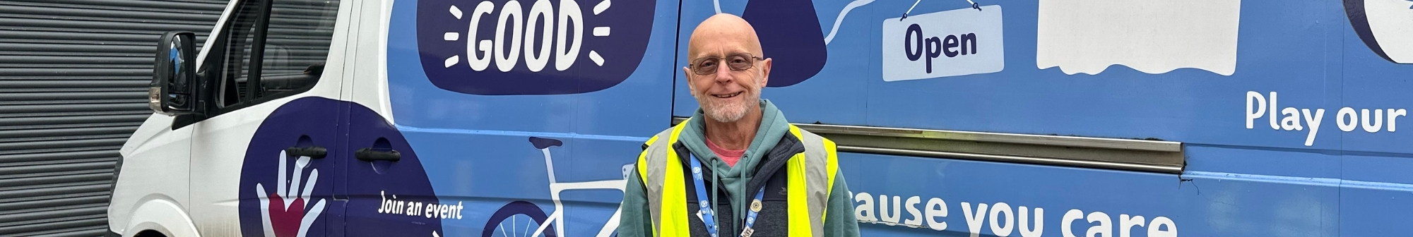 volunteer-stands-and-smiles-in-front-of-hospice-branded-van