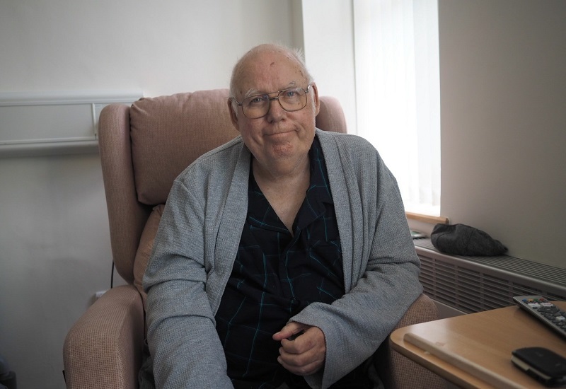 alan-sitting-on-chair-in-ipu-and-smiling