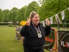 runner-wearing-medal-sticks-tongue-out-and-holds-up-hands-in-peace-symbols-at-the-flawed-hero-marath