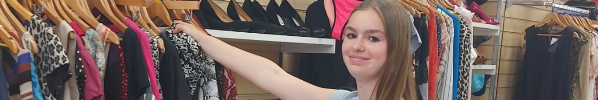 abbie-smiles-at-the-camera-as-she-arranges-clothes-on-rail