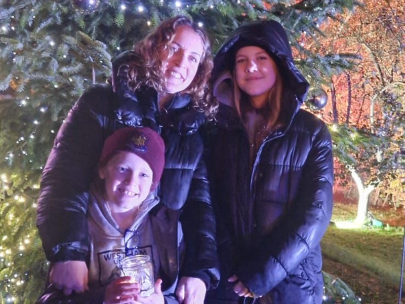 ally-with-her-children-in-front-of-the-chirstmas-tree-at-lights-of-life